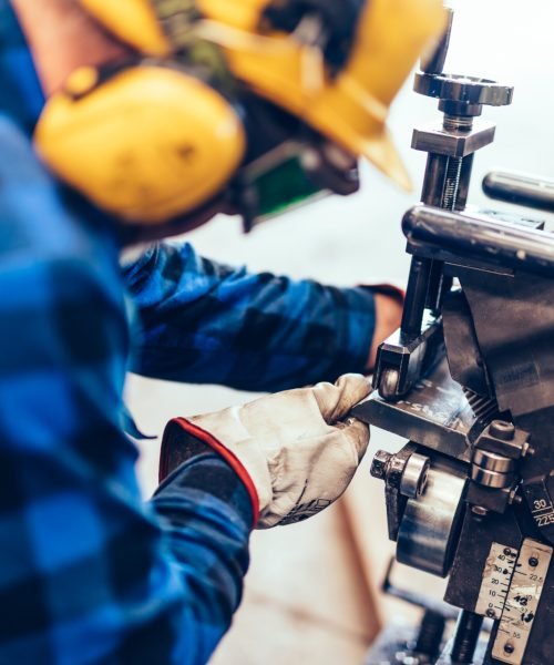 Worker does manual steel plate bevelling process in a factory, workshop. Also chamfering